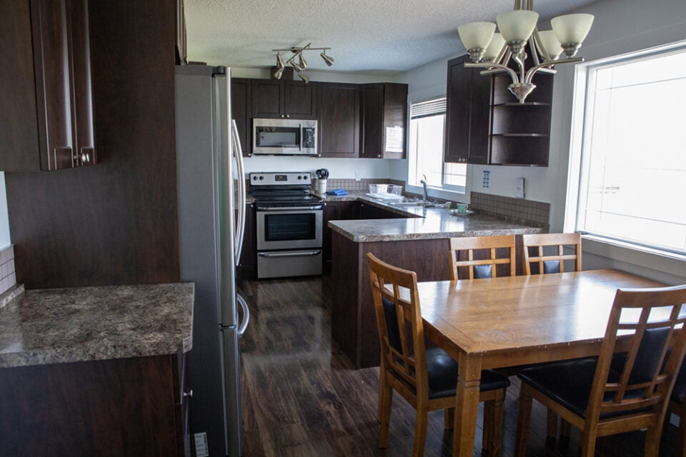 kitchen and dining room showing fridge, stove, counters, cupboards, table and chairs
