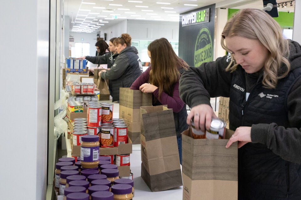 Students put canned food in paper bags