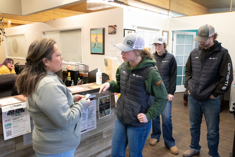 a rodeo student hands the director of the Nawican a cheque