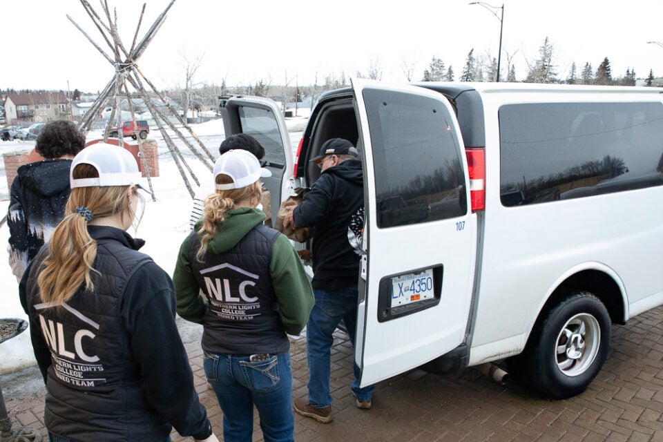 people unload donations from a van
