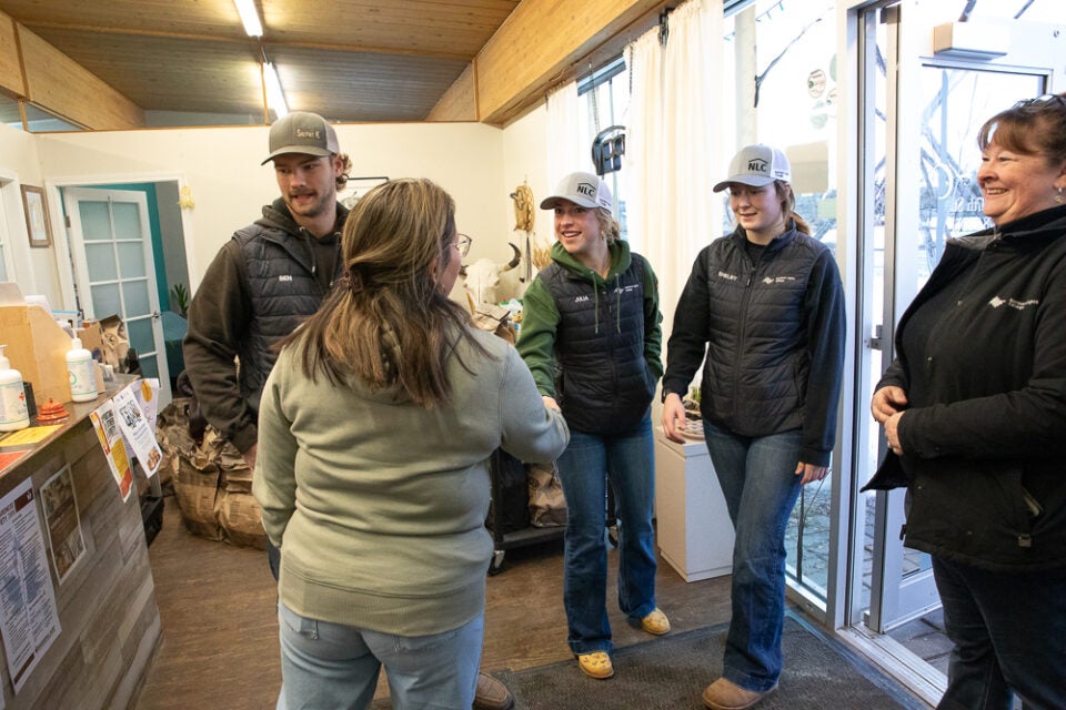 the director of the Nawican shakes hands with a rodeo student while other people look on