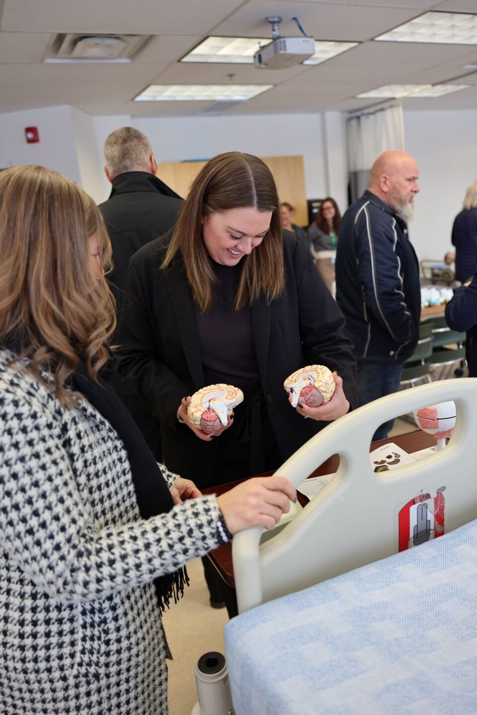 two women look at a model of a brain
