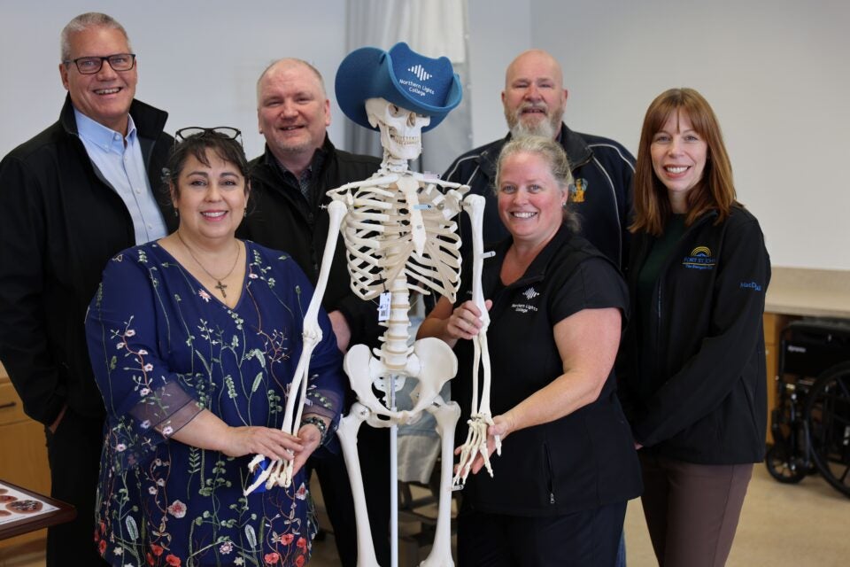 Local politicians, northern health employees and NLC staff stand with a fake skeleton for a picture