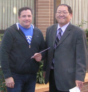 Chris Romano receiving his award from Vice President Academic and Research Peter Nunoda.